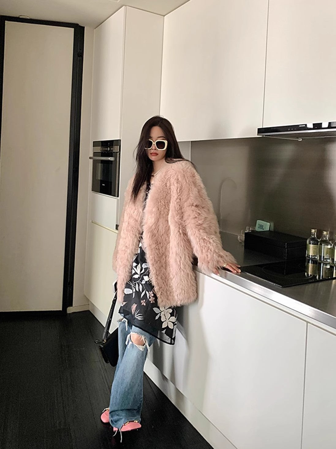 Person wearing a pink fur coat in a kitchen