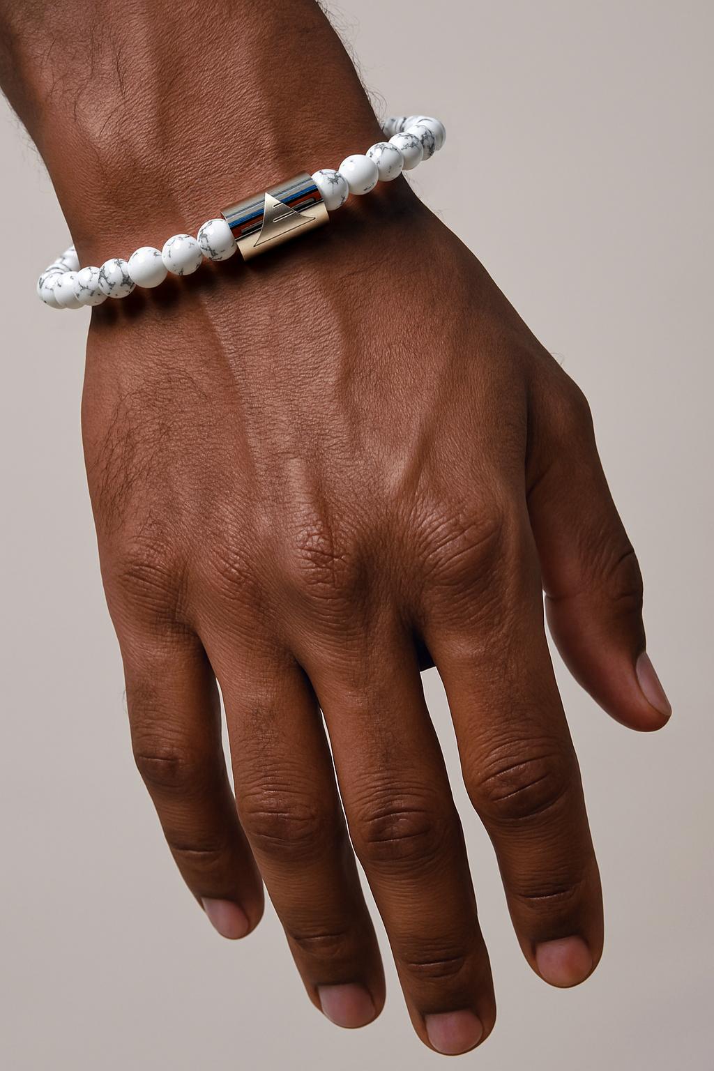 Hand wearing a bracelet with a neutral background