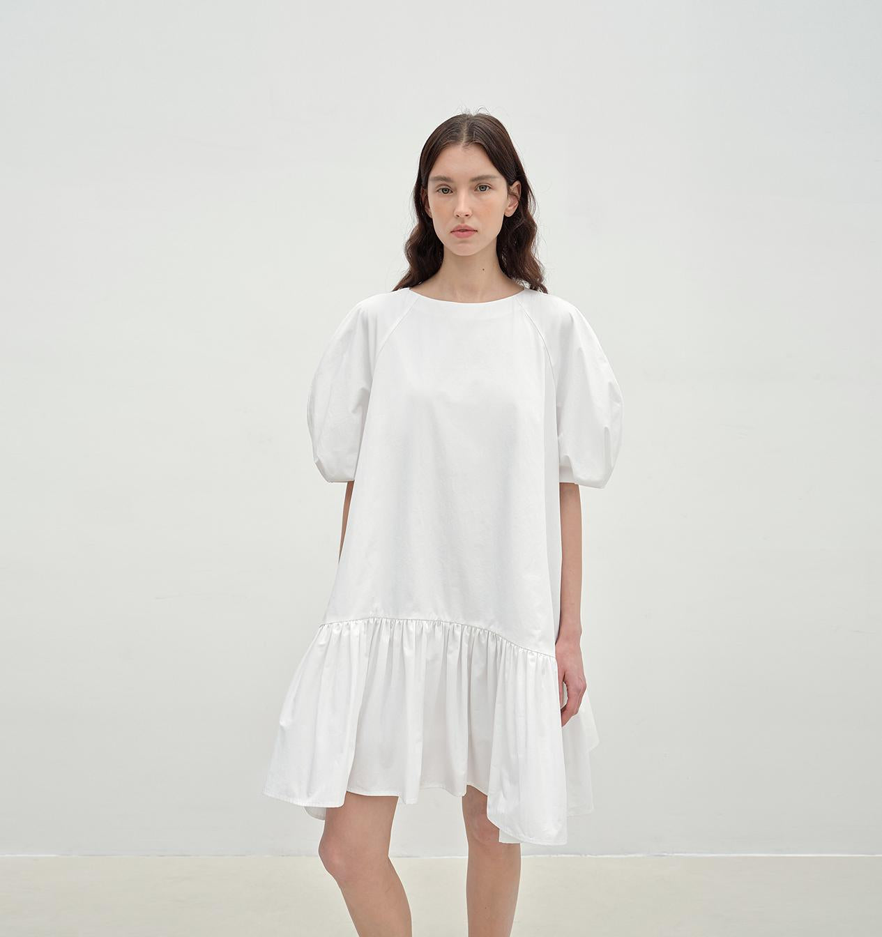 Woman wearing a white dress against a plain background