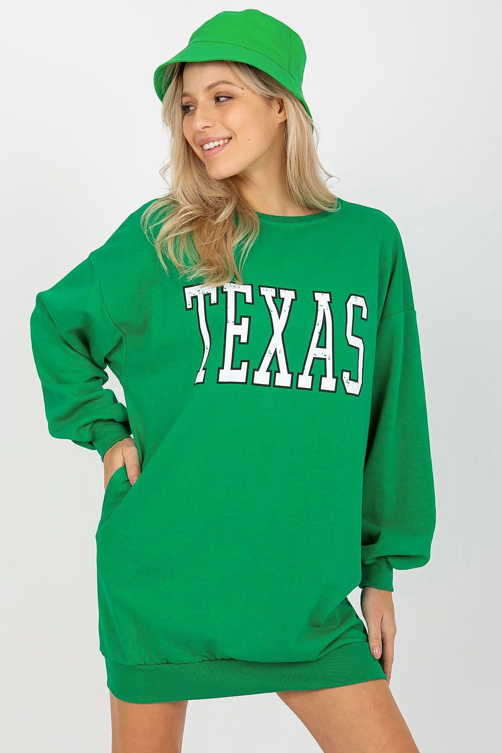 Person wearing a green 'TEXAS' sweatshirt and green cap on a white background