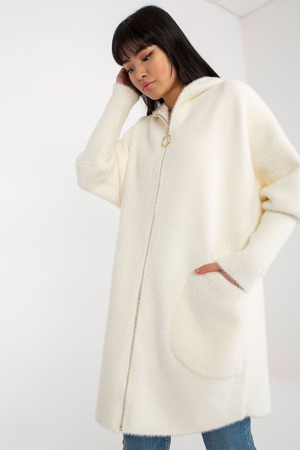 Person wearing a cream-colored coat on a white background