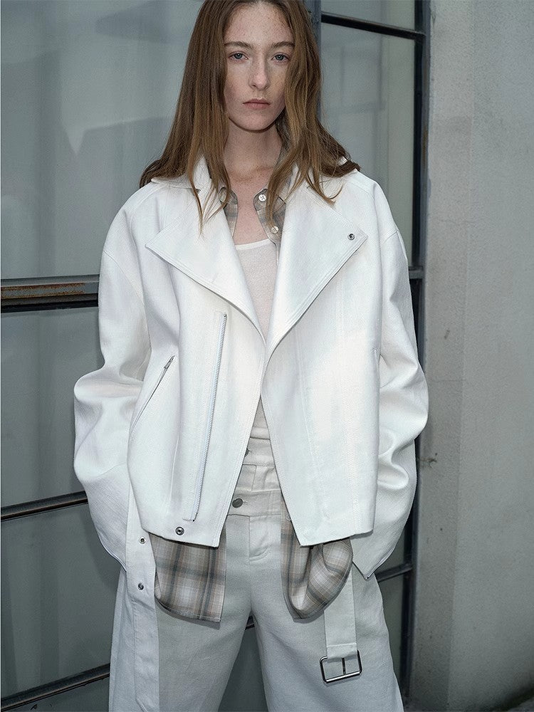 Person wearing a white jacket and pants in an urban setting