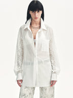 Woman wearing a white shirt with lace sleeves on a white background