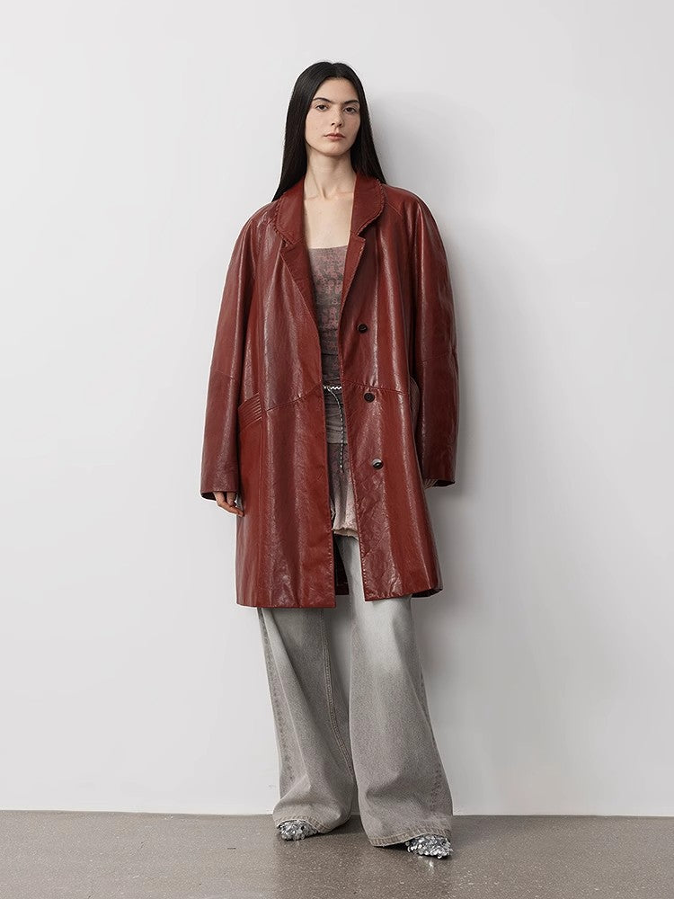 Person wearing a brown leather coat against a plain background