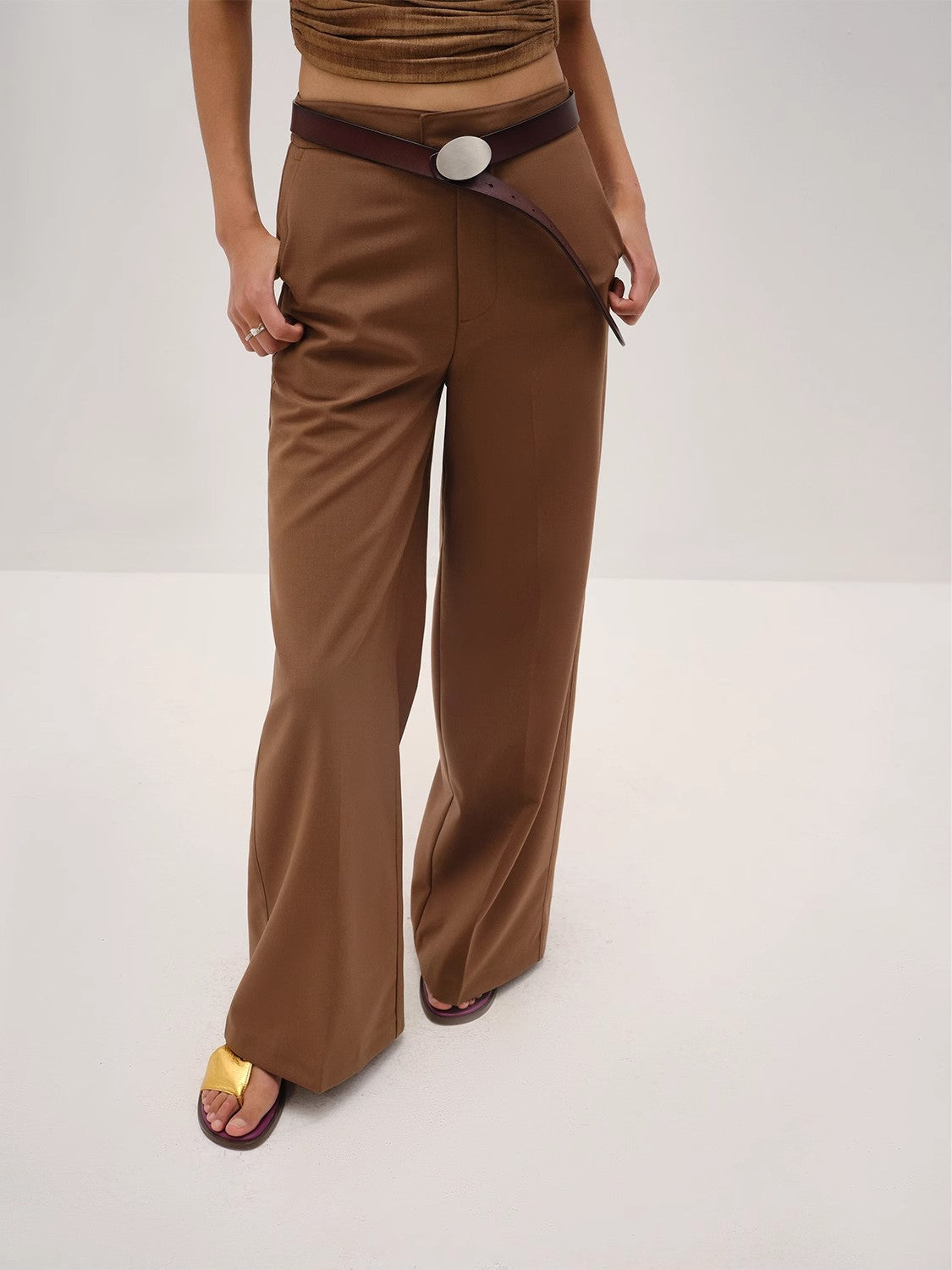 Brown pants with a belt on a white background