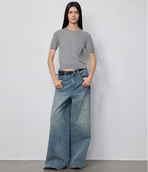 Person wearing a gray t-shirt and blue jeans against a white background