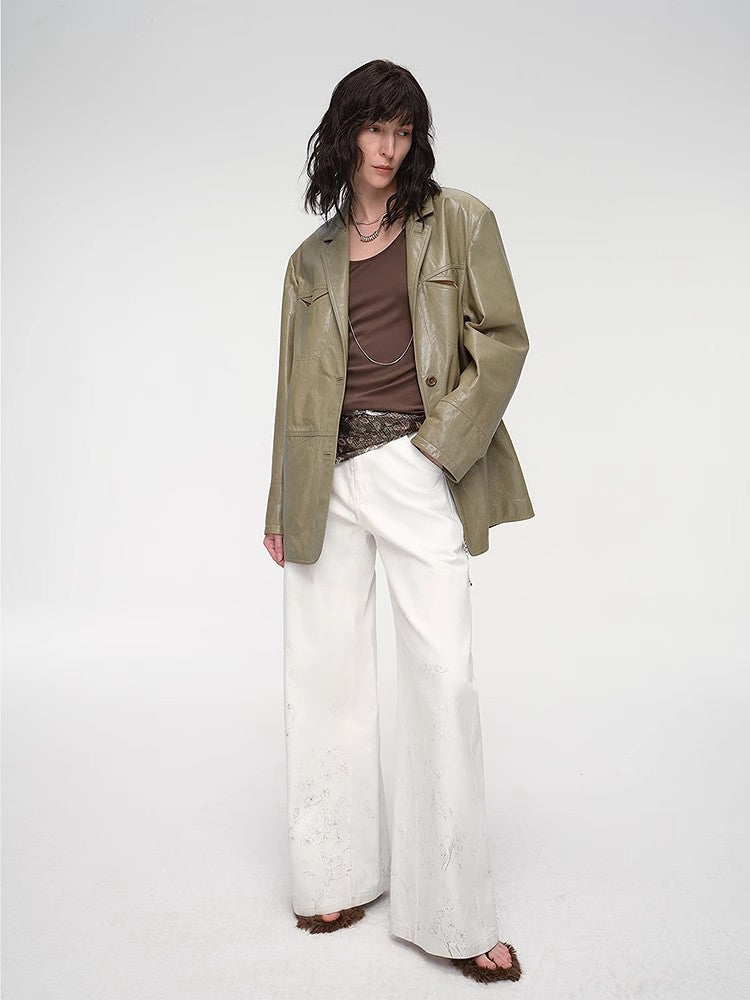 Person wearing a green jacket, brown top, and white pants on a white background