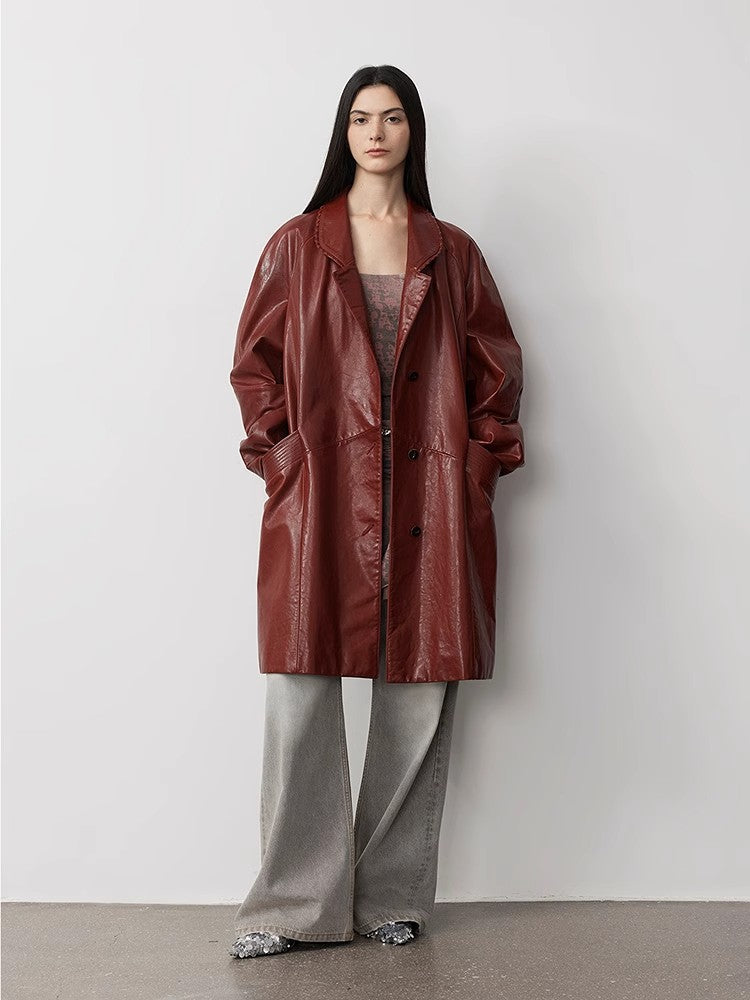 Person wearing a red coat and gray pants against a white background