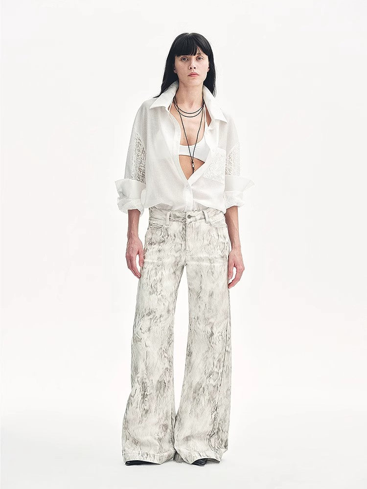 Person wearing a white blouse and patterned pants on a white background