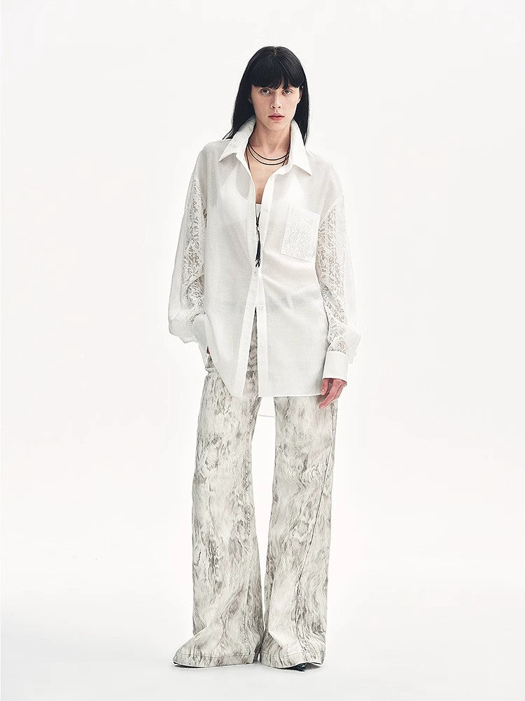 Person wearing a white shirt and patterned pants on a white background