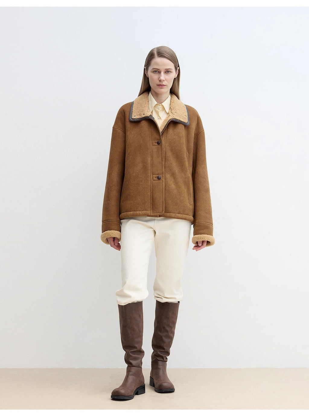 Person wearing a brown jacket and knee-high brown boots on a white background