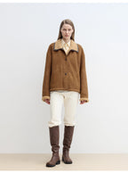 Person wearing a brown jacket and knee-high brown boots on a white background