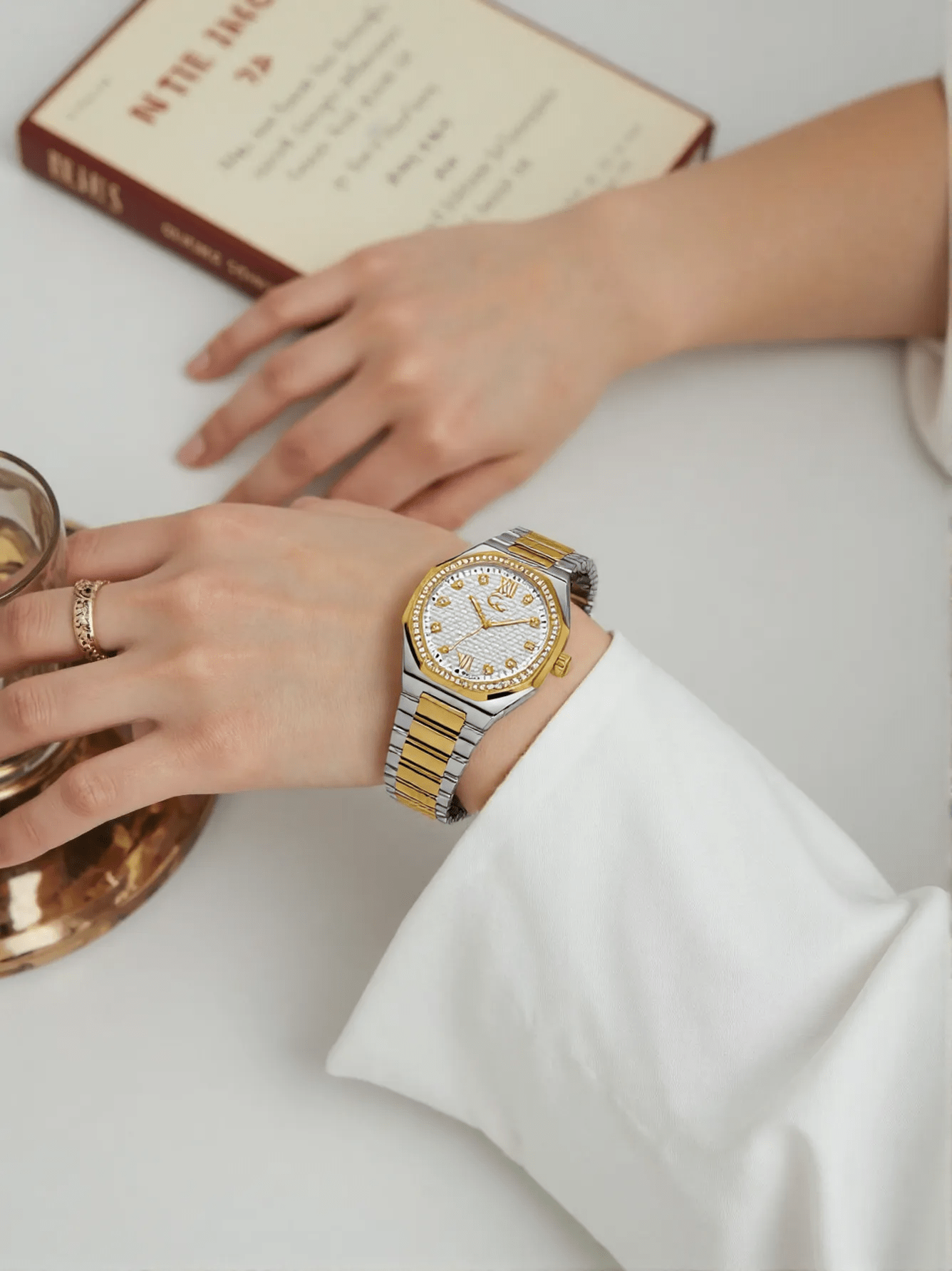 Two-tone silver and gold ladies’ wristwatch with sapphire glass, silver dial, and sparkling stone-set case, featuring Swiss quartz movement and water resistance up to 100 meters.