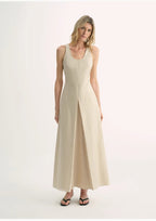 Woman wearing a beige sleeveless dress on a white background