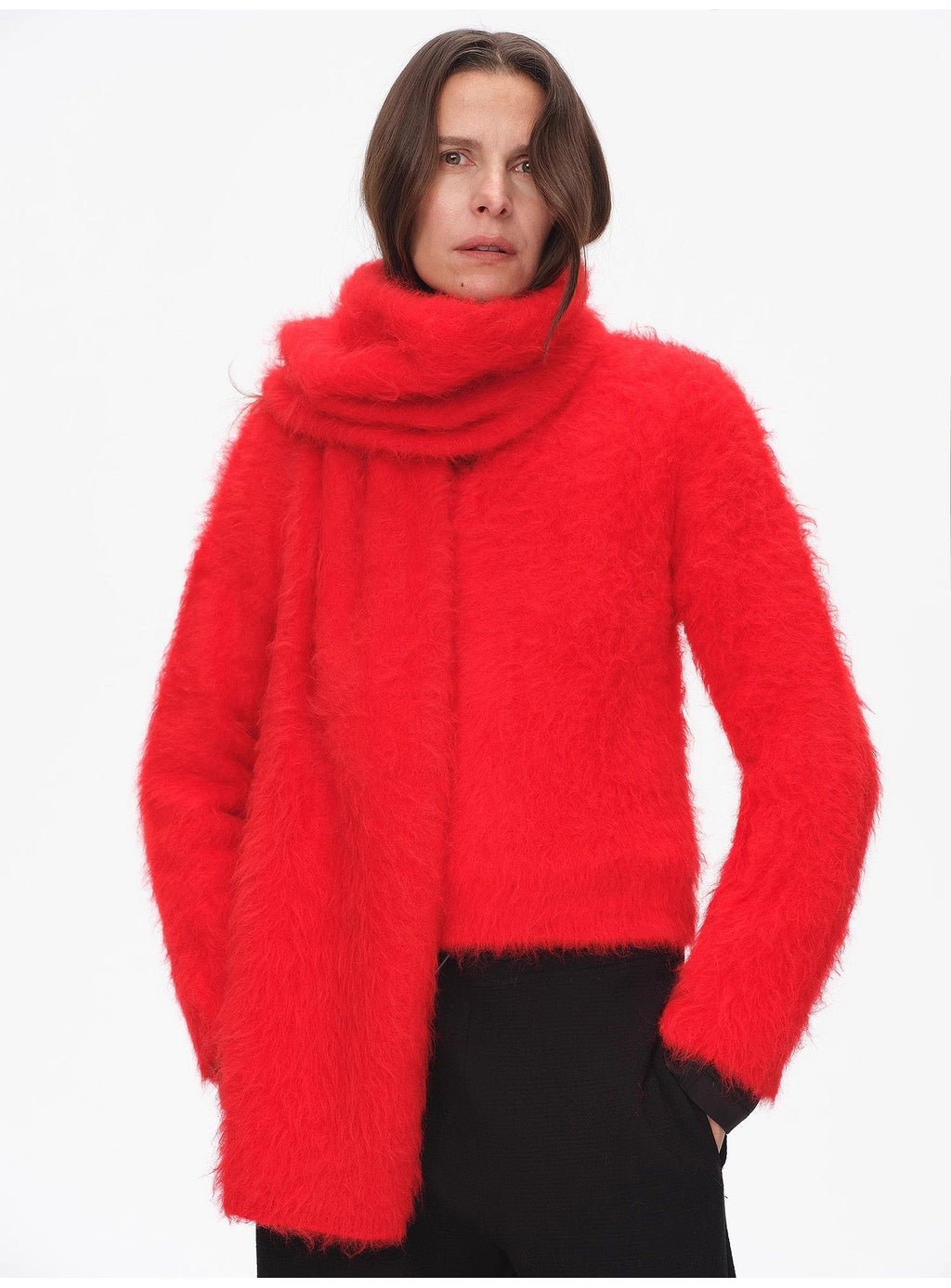 Person wearing a bright red sweater with a white background