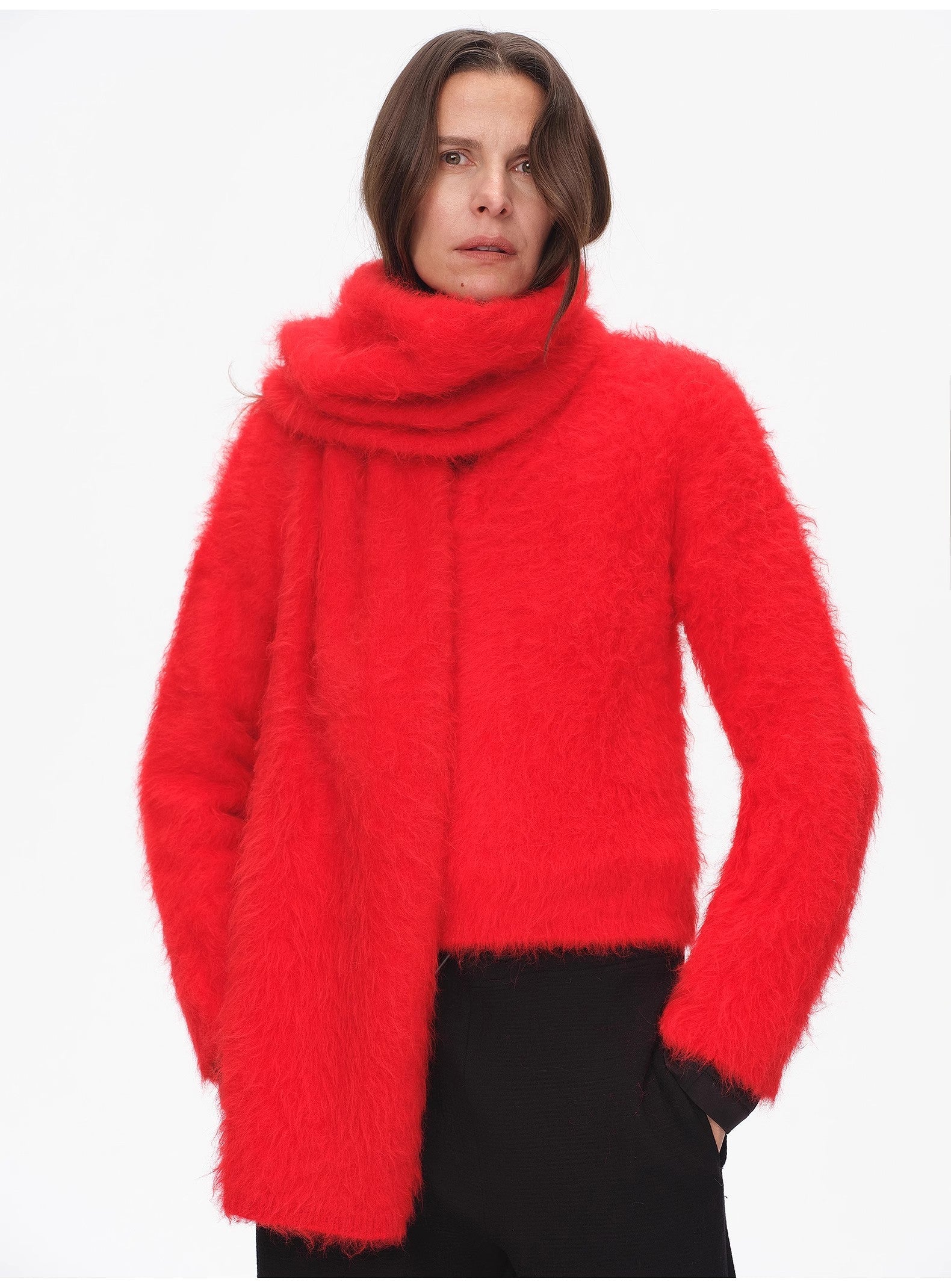 Person wearing a bright red sweater with a white background