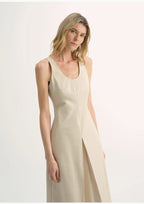 Woman wearing a beige sleeveless dress on a white background