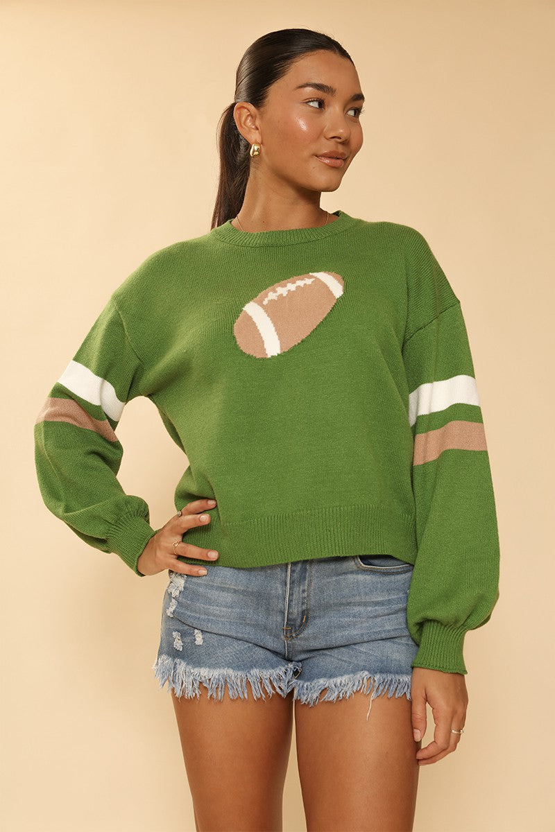 Woman wearing a green sweater with a football design on a beige background
