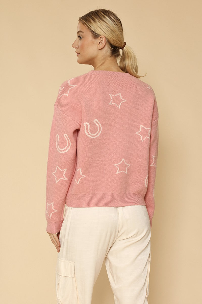 Woman wearing a pink sweater with star patterns on a beige background