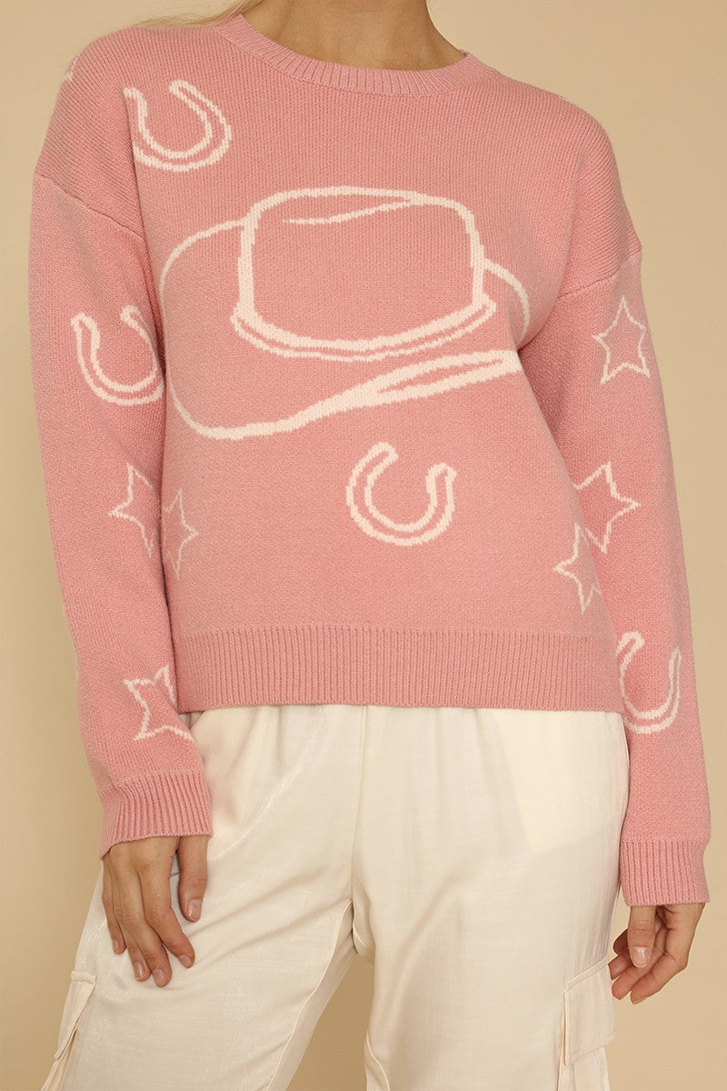 Pink sweater with white graphic designs on a beige background