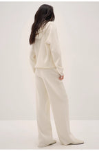 Person wearing a white outfit on a plain background