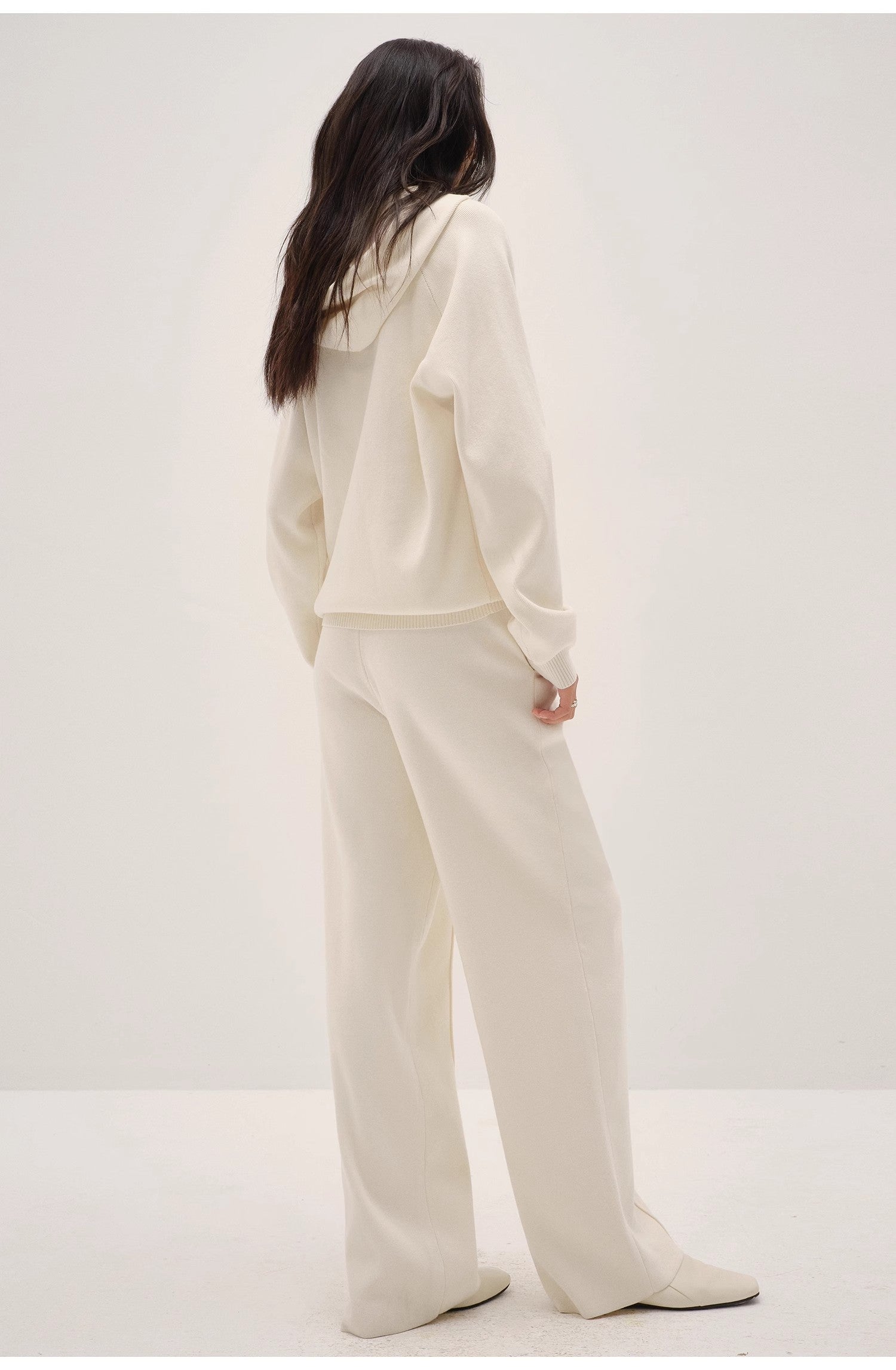 Person wearing a white outfit on a plain background
