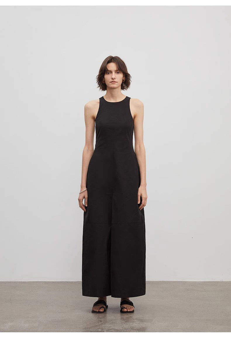 Person wearing a black sleeveless jumpsuit against a plain background
