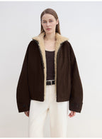 Woman wearing a brown jacket with beige fur lining on a white background