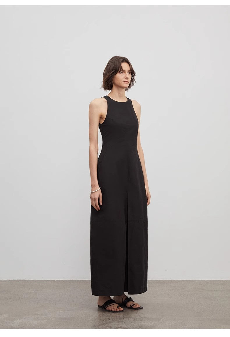 Woman wearing a black sleeveless dress against a plain background