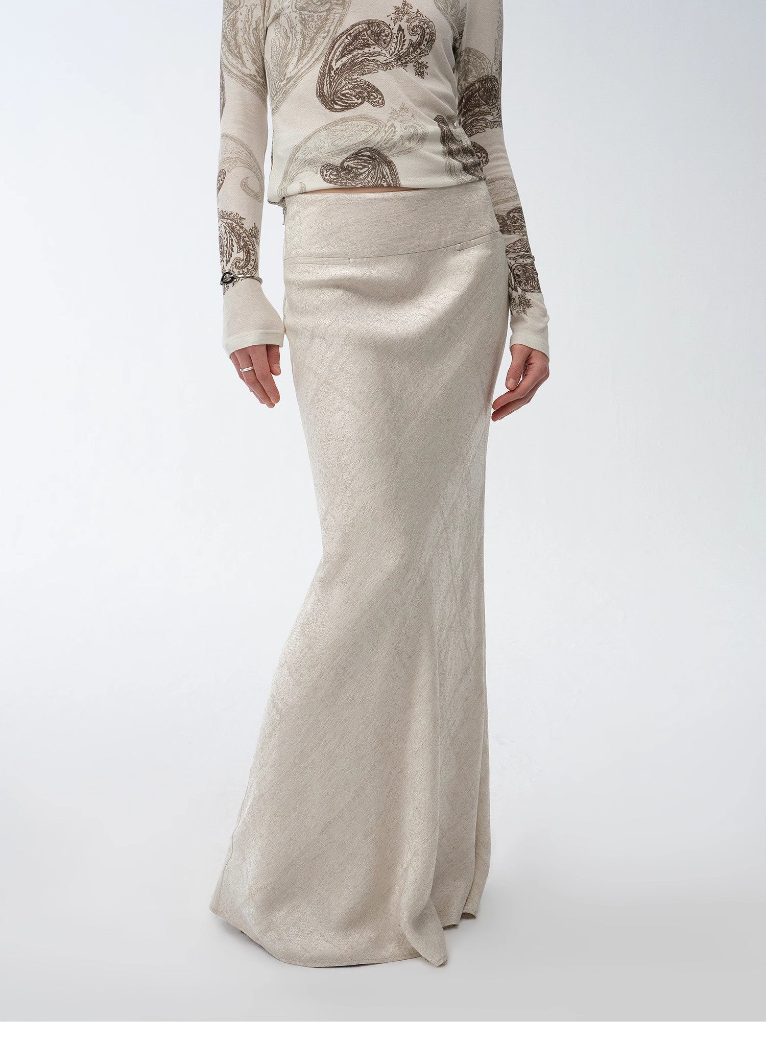 Long beige skirt worn by a person on a white background