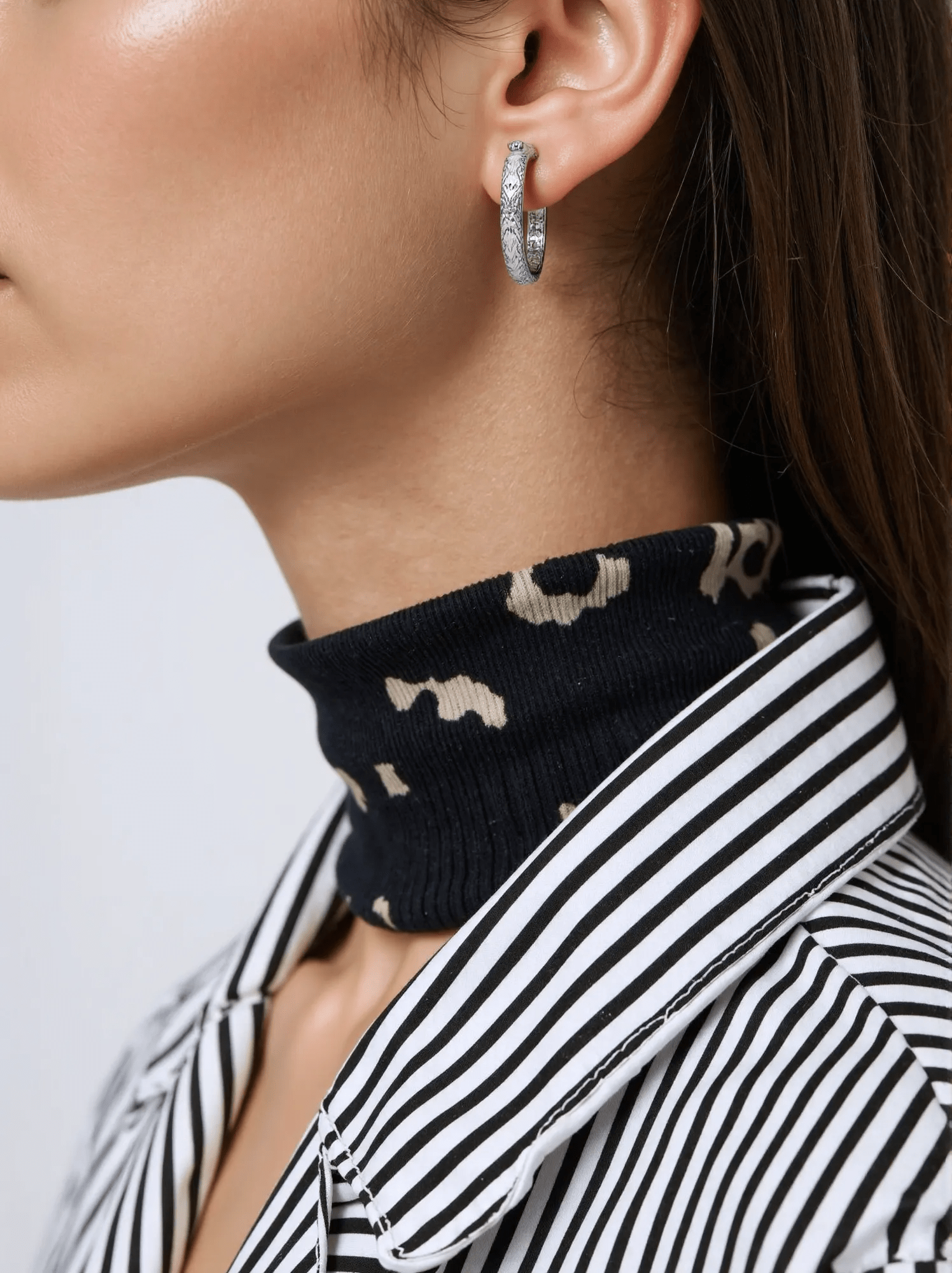 Fine white gold oval hoop earrings with a hammered texture, secured with a snap lock closure for added style and interest.