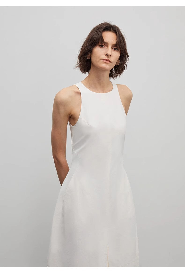 Woman wearing a white sleeveless dress against a plain background