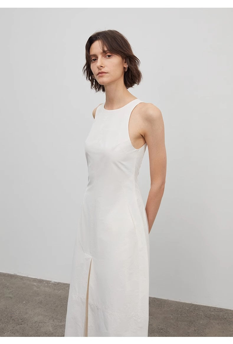 Woman wearing a white sleeveless dress against a plain background