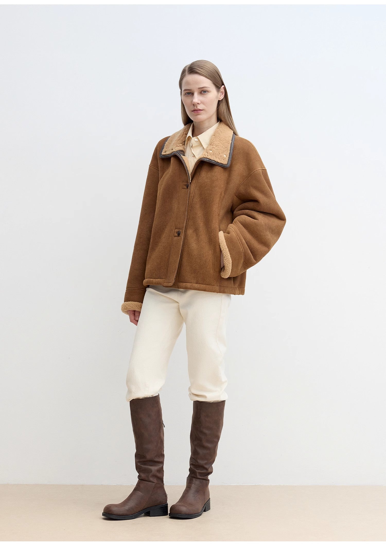 Person wearing a brown coat with a white background