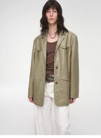 Person wearing a green jacket over a brown top and white pants on a white background