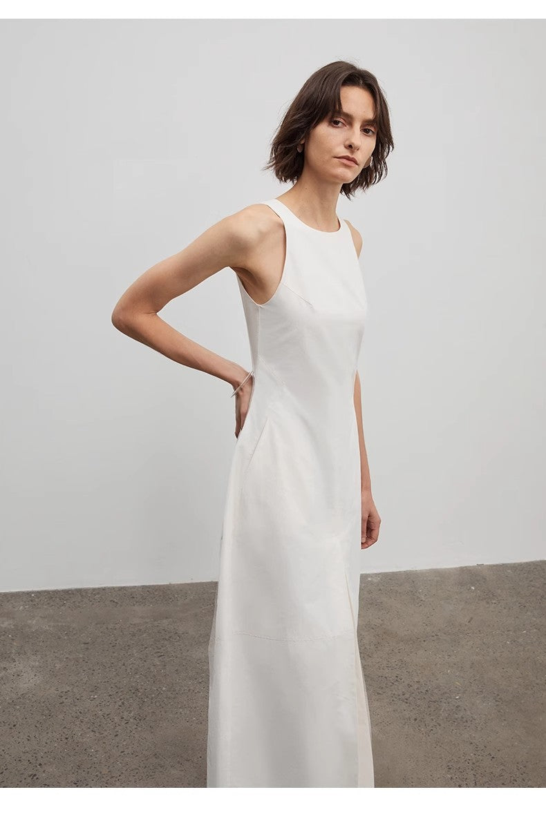 Woman wearing a white sleeveless dress against a plain background