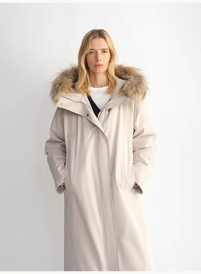 Woman wearing a long coat with a fur-lined hood against a white background