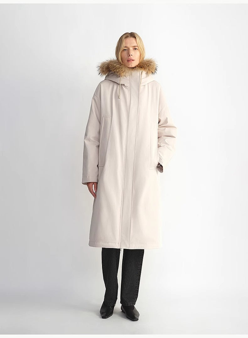 Woman wearing a beige coat with fur hood on a white background