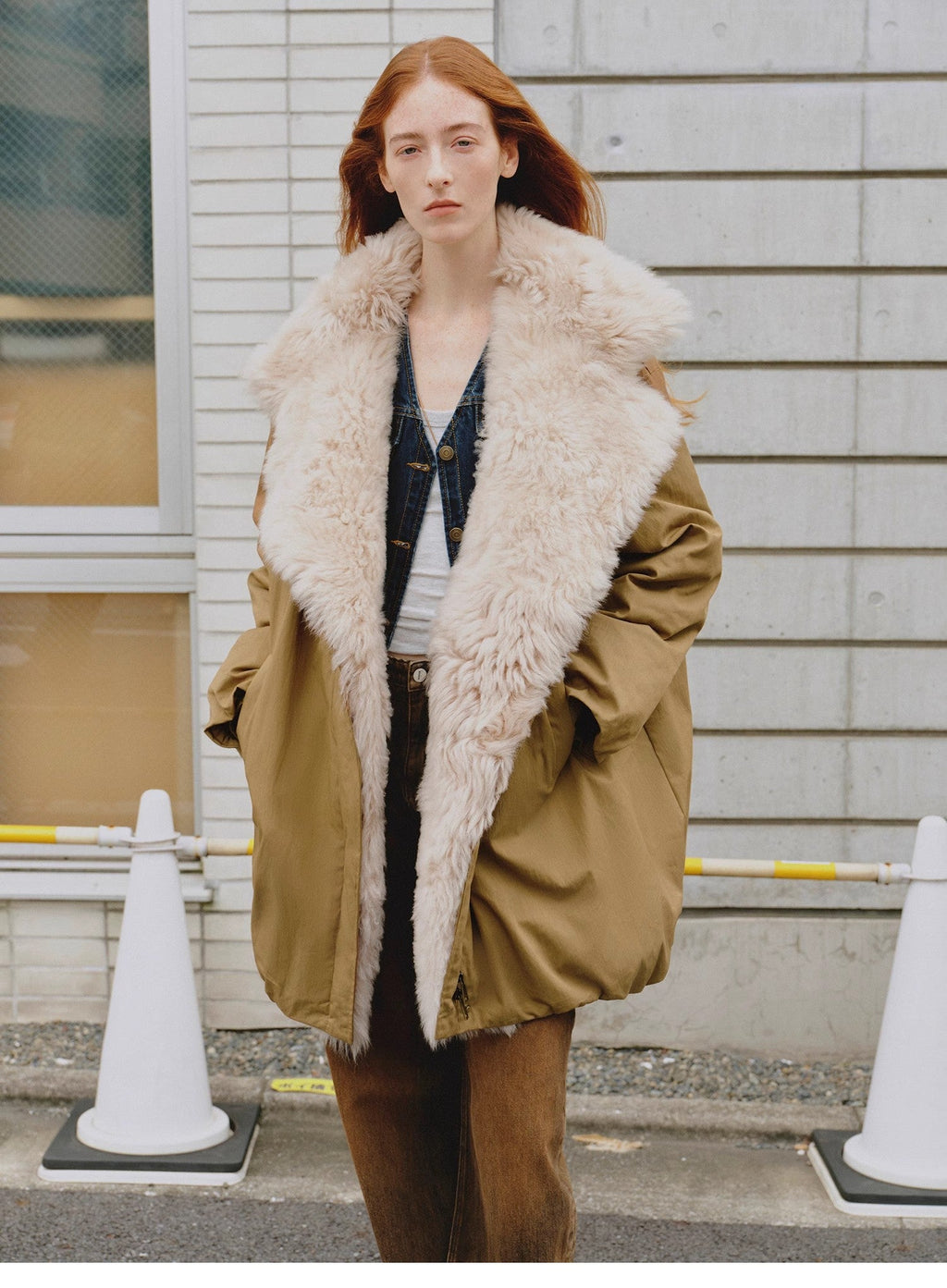 Woman wearing a beige coat with a fur-lined hood in an urban setting