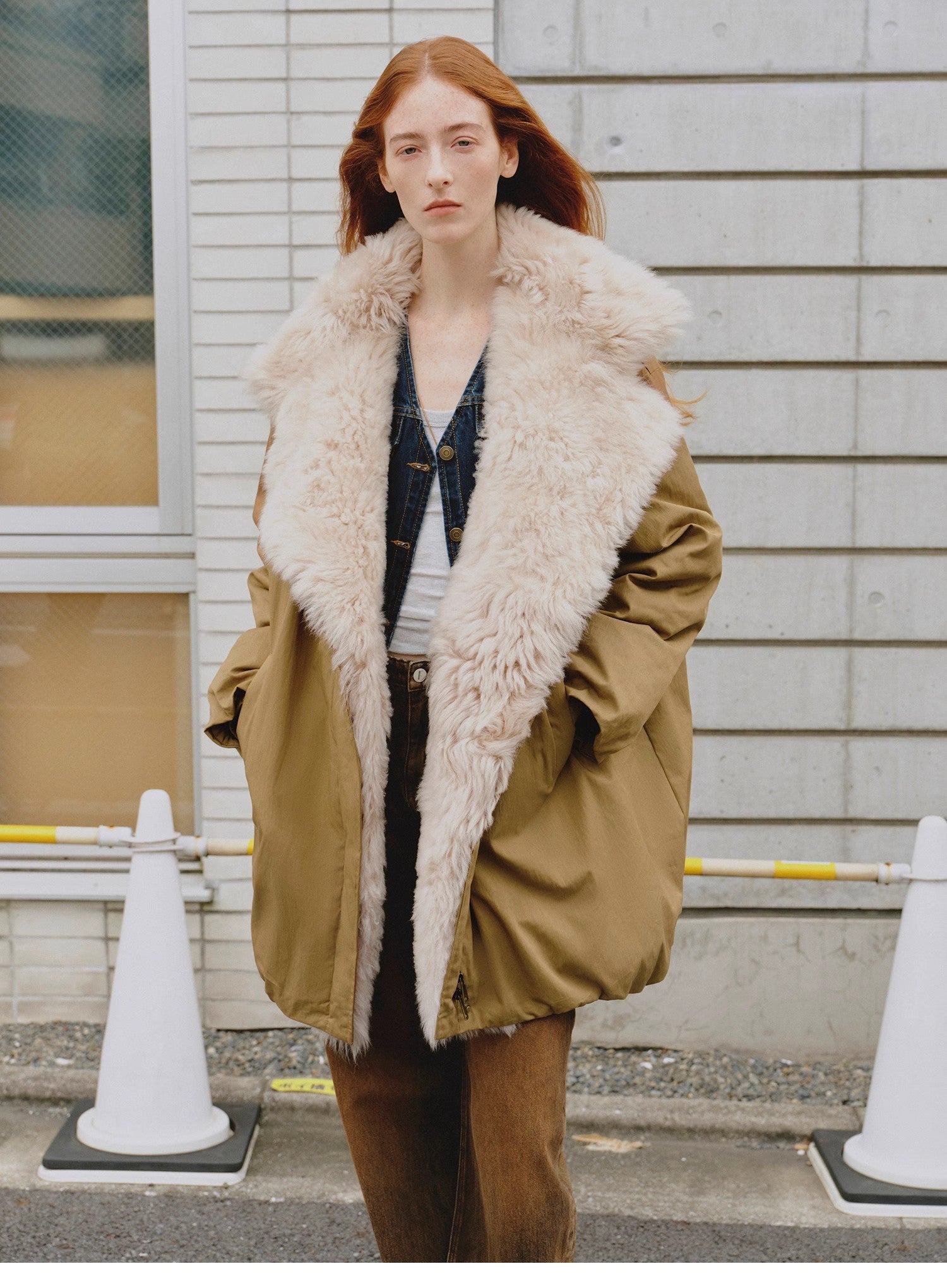 Woman wearing a beige coat with a fur-lined hood in an urban setting