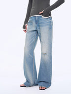 Person wearing light blue jeans on a white background