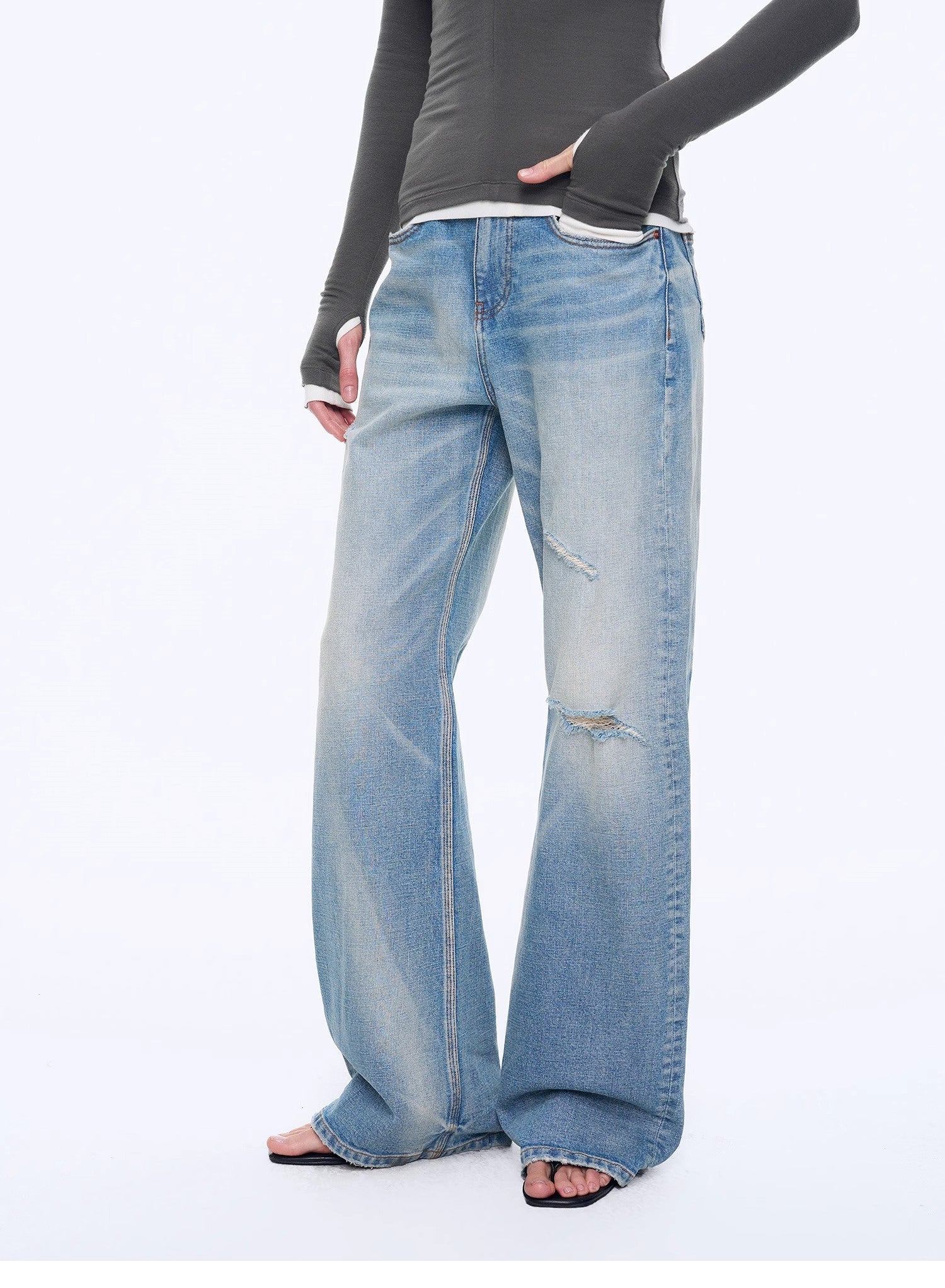 Person wearing light blue jeans on a white background
