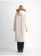 Person wearing a beige coat with fur hood on a white background