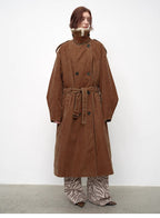 Person wearing a long brown coat with a white background