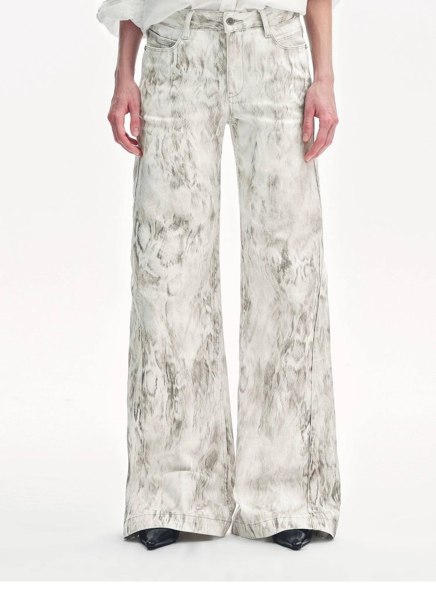 Person wearing wide-leg pants with a subtle pattern on a white background