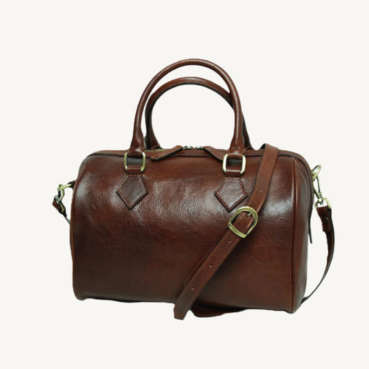Full-grain leather shoulder bag with double handles, adjustable strap, two interior zipped pockets, bottom feet, and polyester lining; size 31x20x18 cm.