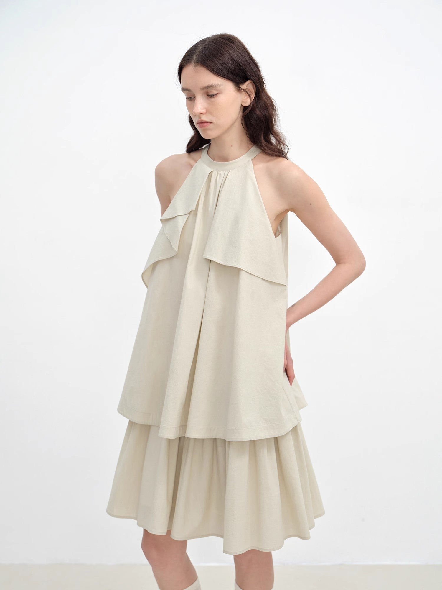 Woman wearing a beige layered dress on a white background