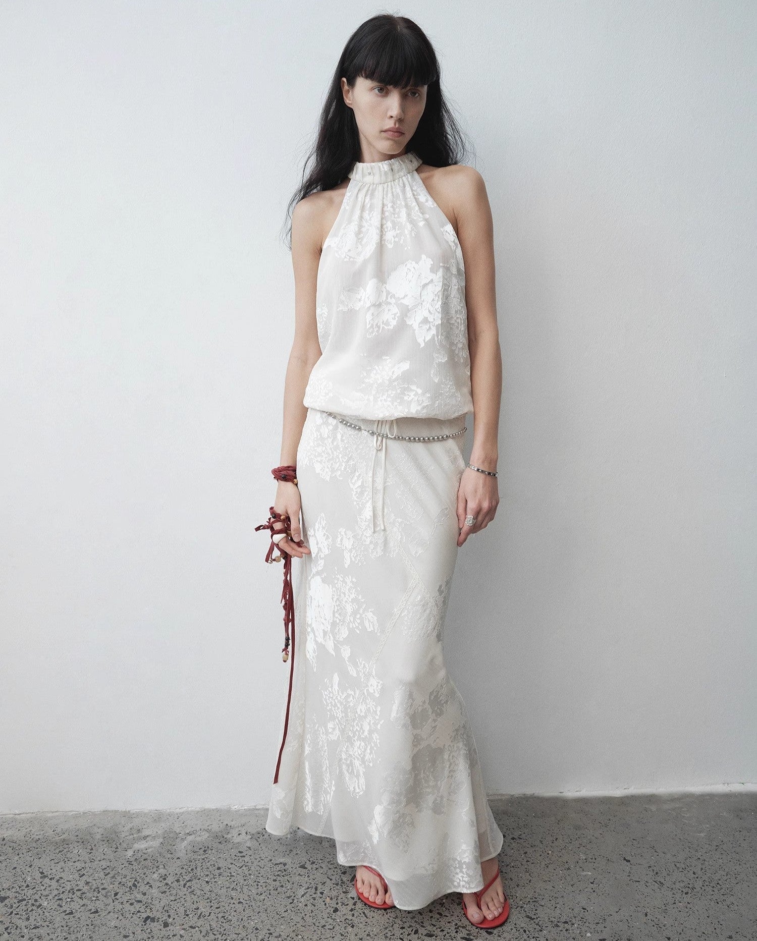Woman wearing a white lace dress against a plain background