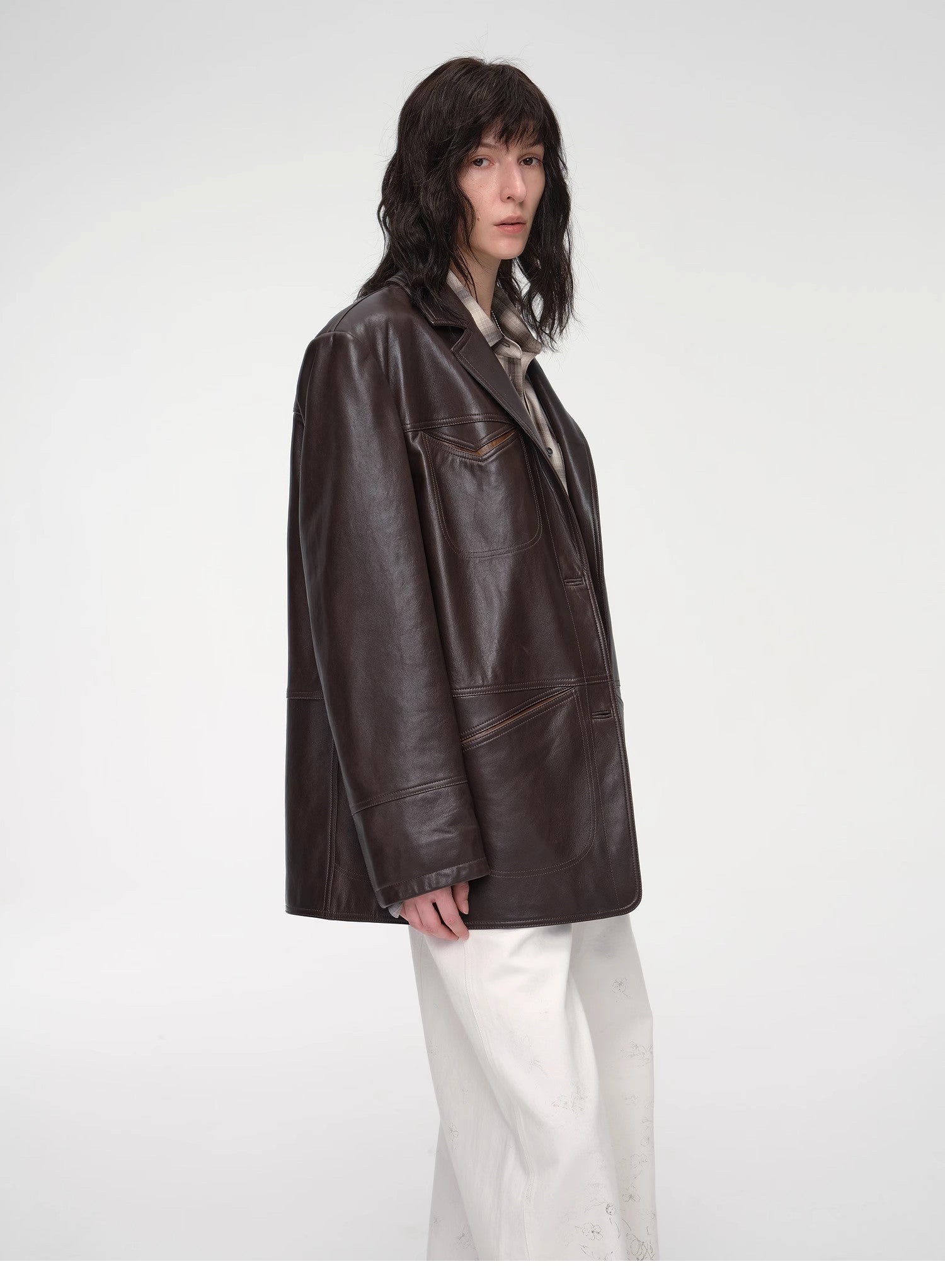 Person wearing a brown leather jacket on a white background