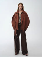 Model wearing a brown coat and pants on a white background